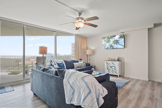 living room featuring ceiling fan, light hardwood / wood-style floors, and a healthy amount of sunlight