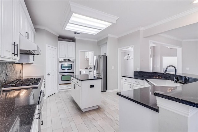 kitchen featuring stainless steel appliances, a kitchen island, crown molding, pendant lighting, and white cabinets