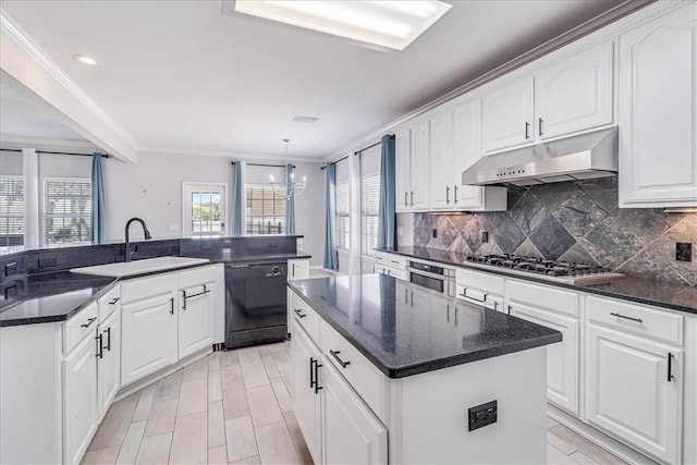 kitchen with a kitchen island with sink, an inviting chandelier, white cabinets, sink, and appliances with stainless steel finishes