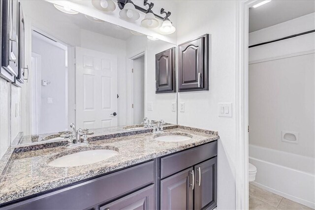 bathroom with tile patterned flooring, vanity, and toilet