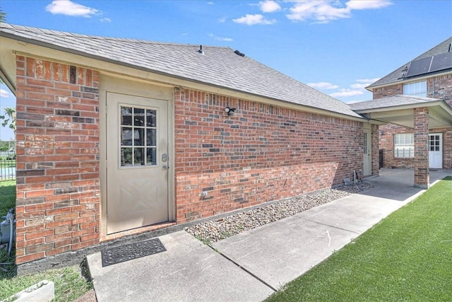 10 W Bar Le Doc Dr, Corpus Christi, TX 78414 - property entrance featuring brick siding, a patio area, and roof with shingles