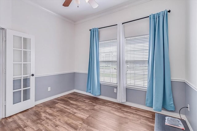 empty room featuring ceiling fan, wood-type flooring, and ornamental molding