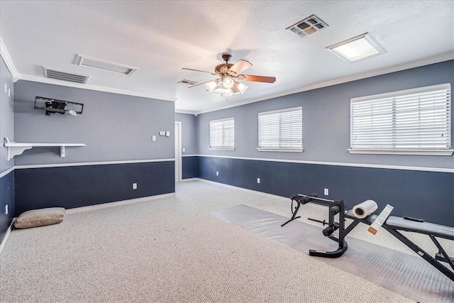 workout room with a textured ceiling, ceiling fan, and ornamental molding