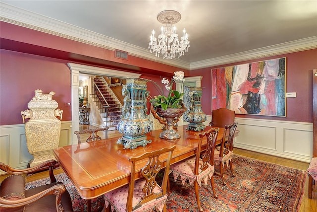 215 Oleander, Corpus Christi, TX 78404 - dining area with a chandelier, ornamental molding, wood finished floors, wainscoting, and a decorative wall