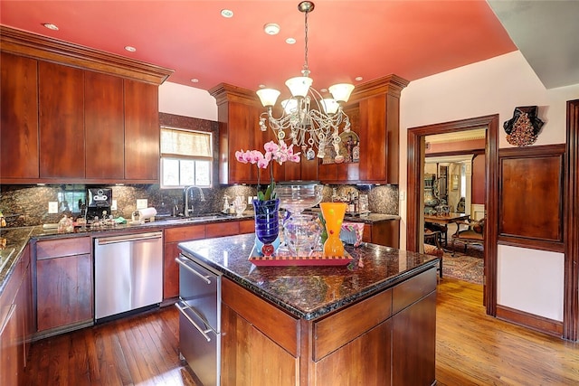 215 Oleander, Corpus Christi, TX 78404 - kitchen with stainless steel dishwasher, a chandelier, dark wood finished floors, a sink, and a center island