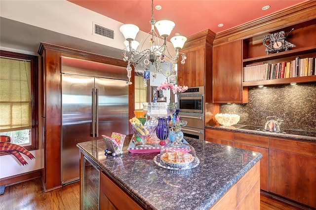 215 Oleander, Corpus Christi, TX 78404 - kitchen featuring built in appliances, beverage cooler, a chandelier, dark wood finished floors, and backsplash
