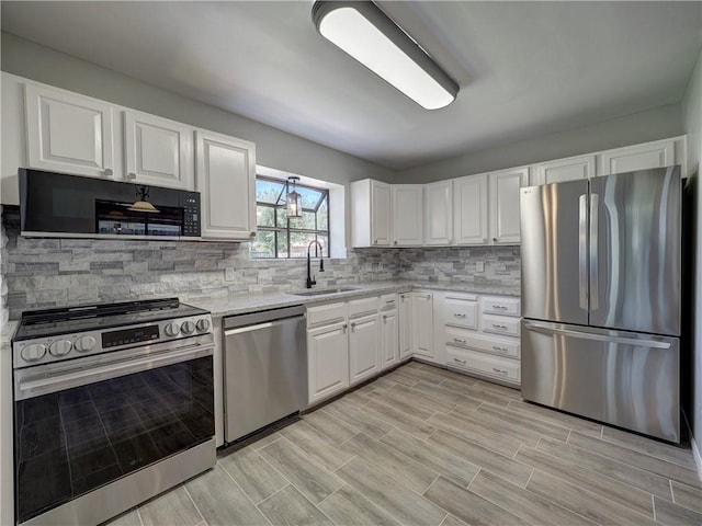 4753 Sierra Blanca Blvd, Corpus Christi, TX 78413 - kitchen with appliances with stainless steel finishes, white cabinetry, tasteful backsplash, and light stone countertops