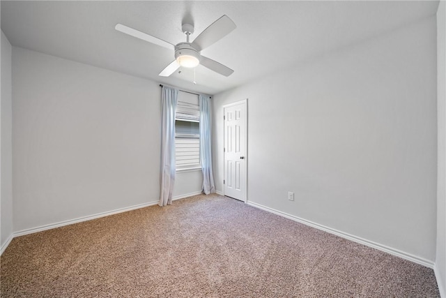 spare room featuring a ceiling fan, light colored carpet, and baseboards