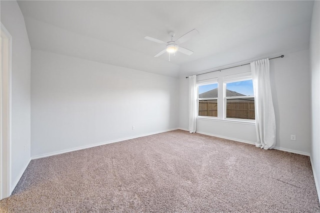 carpeted spare room featuring ceiling fan and baseboards