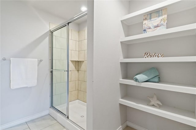 full bath featuring tile patterned floors, a shower stall, and baseboards