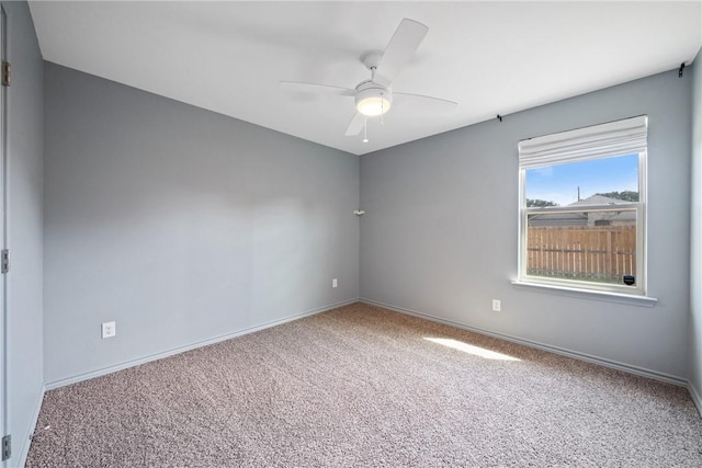 spare room featuring carpet, baseboards, and a ceiling fan