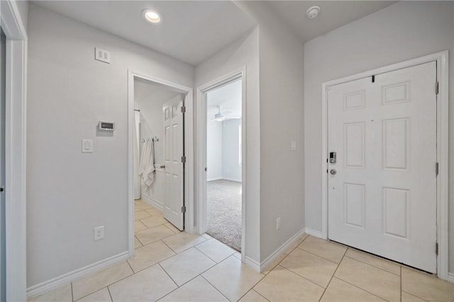 foyer entrance featuring recessed lighting, light carpet, baseboards, and light tile patterned floors