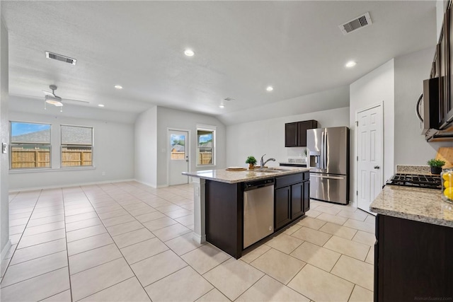 kitchen with open floor plan, stainless steel appliances, a center island with sink, and visible vents