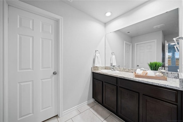 bathroom with vanity, baseboards, and tile patterned floors