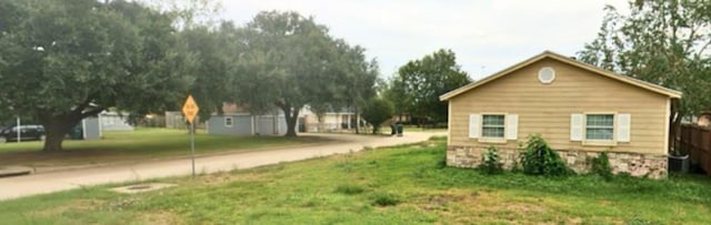 view of property exterior featuring a lawn and fence