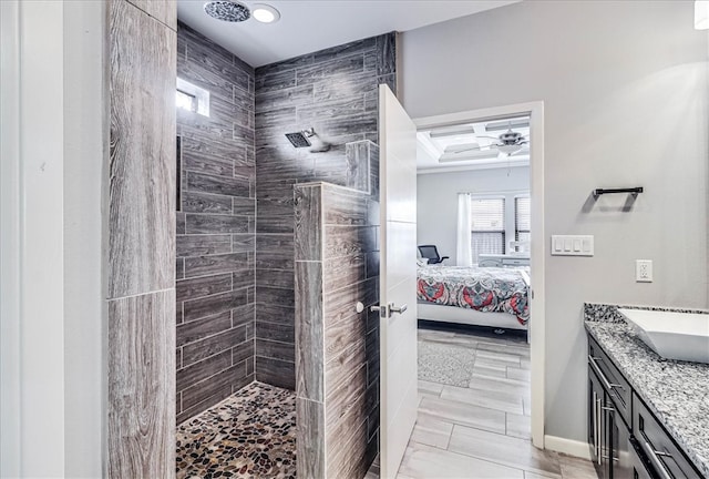 bathroom featuring tiled shower, vanity, and ceiling fan