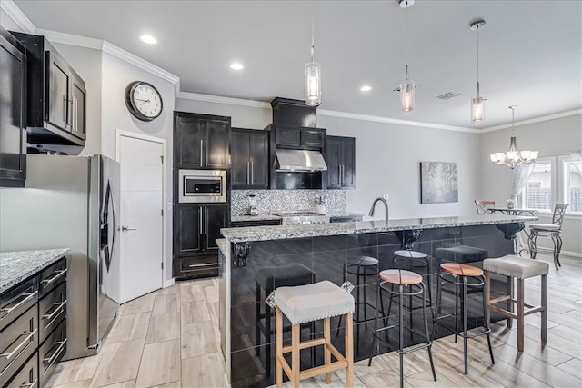 kitchen featuring appliances with stainless steel finishes, pendant lighting, a kitchen breakfast bar, and a large island