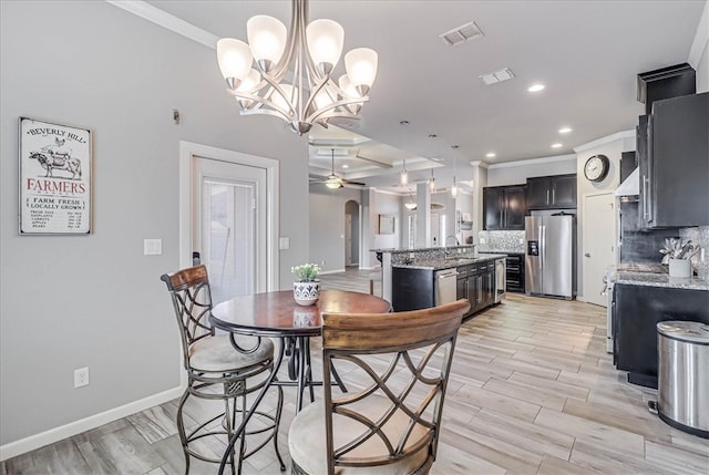 dining space with ceiling fan with notable chandelier, light hardwood / wood-style floors, crown molding, and sink