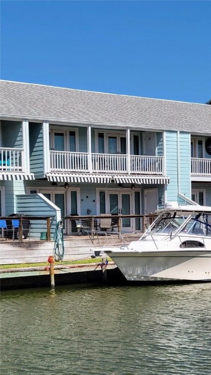 rear view of house featuring a balcony and a water view