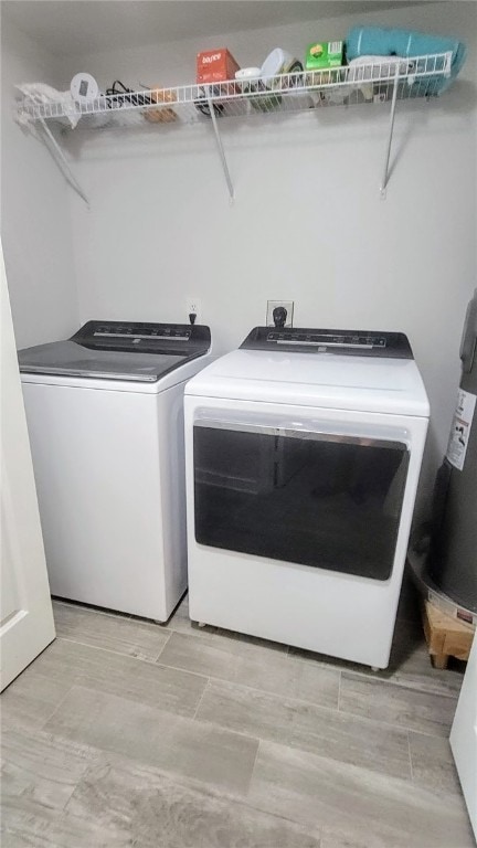 laundry room featuring washing machine and clothes dryer and light wood-type flooring