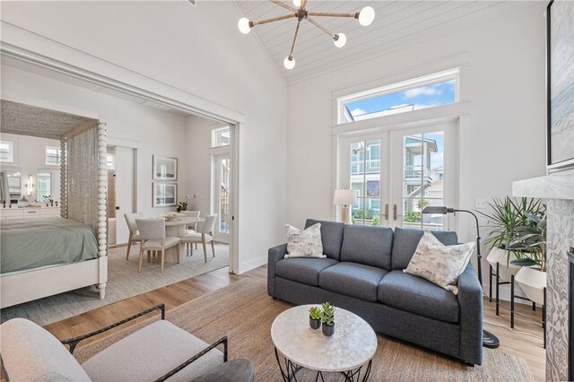 673 Center S Unit 21, Port Aransas, TX 78373 - living room featuring high vaulted ceiling, french doors, light wood-style flooring, and a chandelier