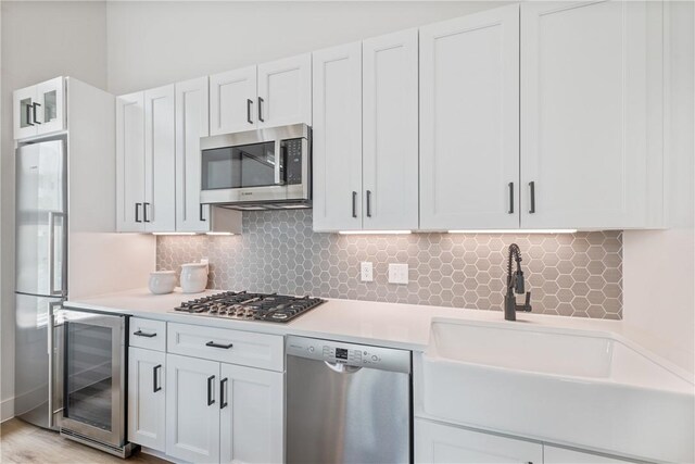 673 Center S Unit 21, Port Aransas, TX 78373 - kitchen with stainless steel appliances, wine cooler, light countertops, a sink, and decorative backsplash
