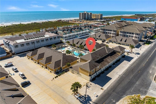 birds eye view of property with a water view and a view of the beach