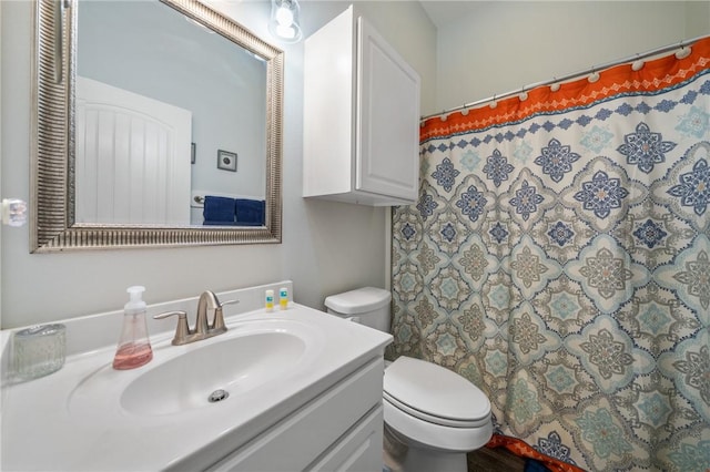 bathroom with vanity, curtained shower, and toilet