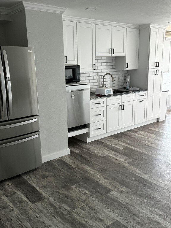 kitchen with white cabinetry, stainless steel appliances, and dark hardwood / wood-style flooring