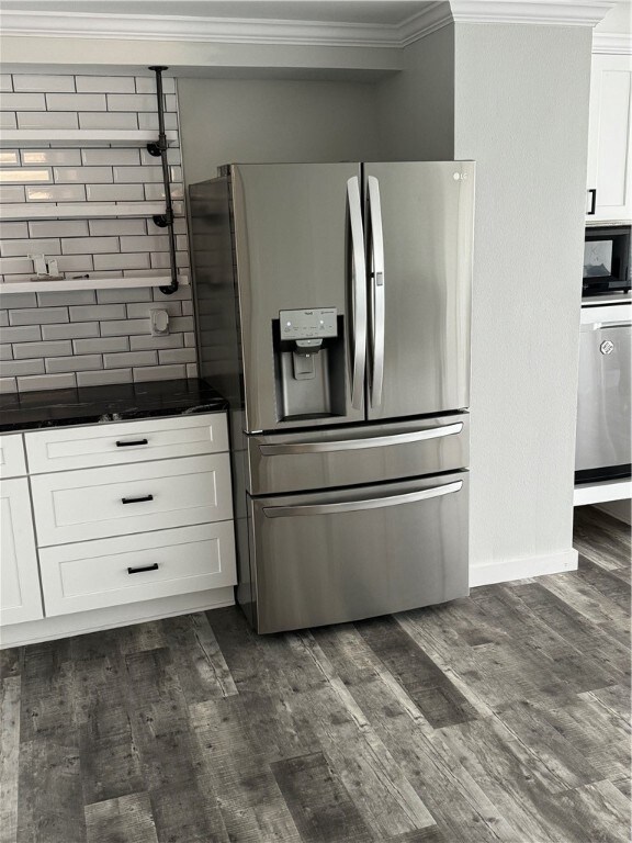 kitchen with stainless steel appliances, dark hardwood / wood-style floors, crown molding, white cabinets, and decorative backsplash