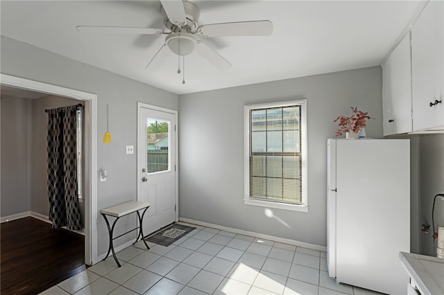 foyer with ceiling fan, plenty of natural light, and light tile patterned floors