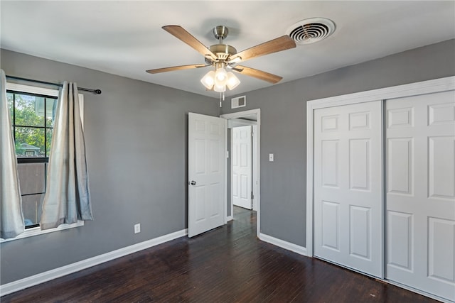 unfurnished bedroom with ceiling fan, dark hardwood / wood-style floors, and a closet