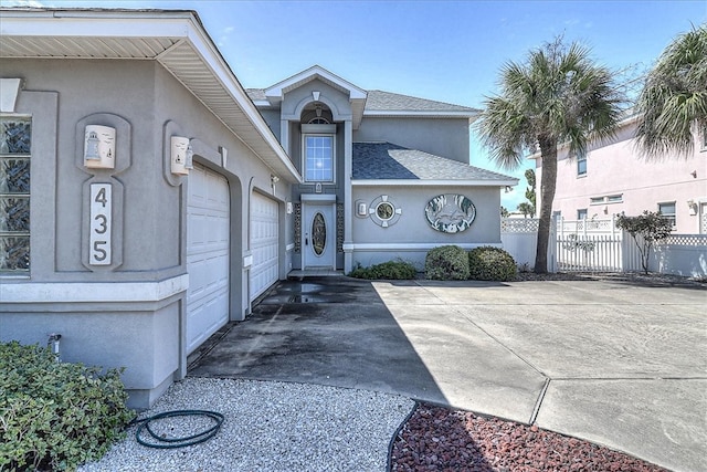 exterior space featuring stucco siding, a shingled roof, concrete driveway, fence, and a garage