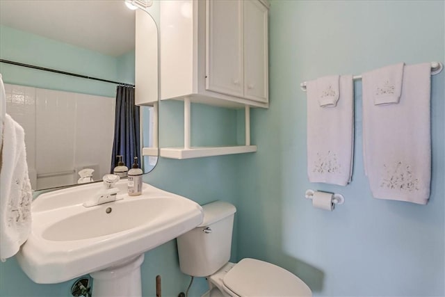 full bath with a shower with shower curtain, a sink, and toilet