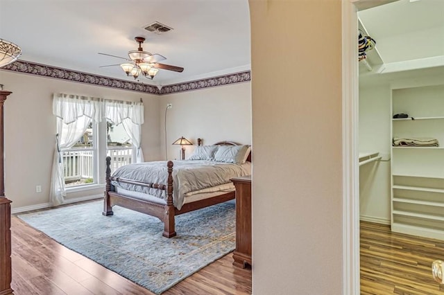 bedroom featuring access to outside, wood finished floors, and visible vents