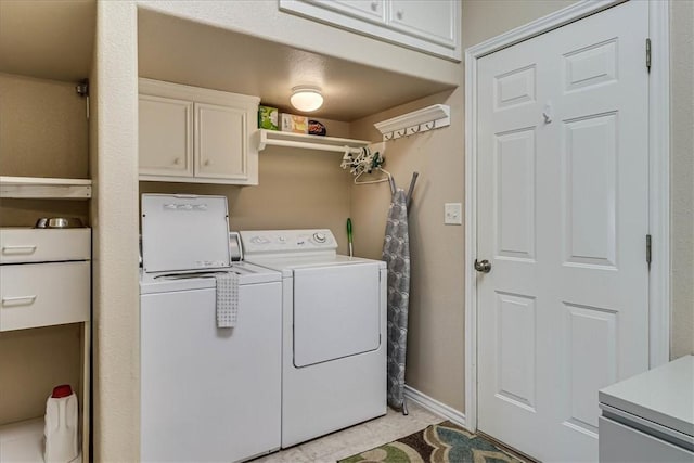 laundry room with cabinet space, baseboards, and washer and dryer