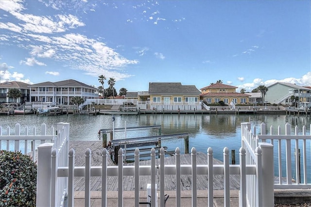 view of dock with a residential view and a water view