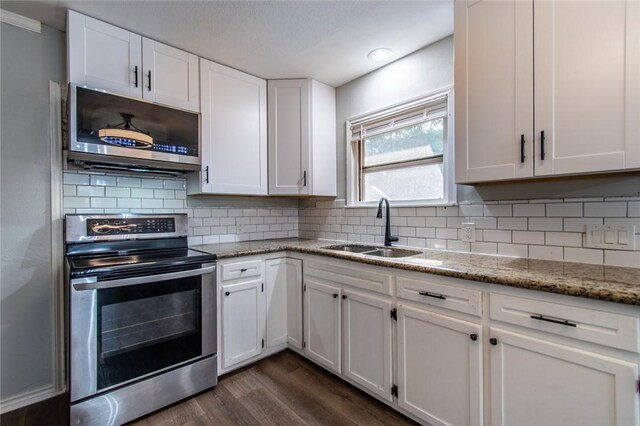 4001 Cott St, Corpus Christi, TX 78411 - kitchen featuring stainless steel appliances, a sink, dark wood-style flooring, white cabinetry, and light stone counters