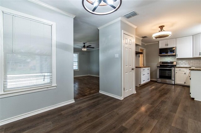 4001 Cott St, Corpus Christi, TX 78411 - kitchen with stainless steel appliances, ornamental molding, dark wood-style floors, white cabinets, and ceiling fan