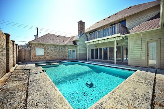 view of pool featuring a fenced backyard and a pool with connected hot tub