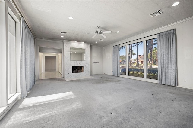 unfurnished living room with a premium fireplace, visible vents, crown molding, and recessed lighting