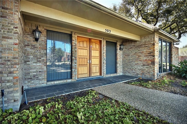 view of exterior entry featuring brick siding