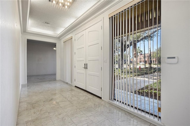 entryway with marble finish floor, a textured ceiling, and crown molding