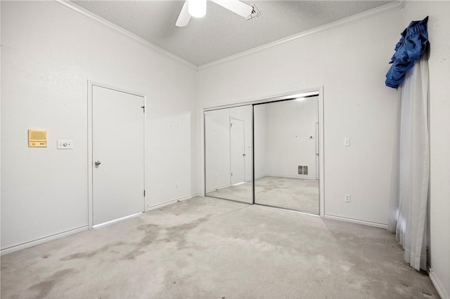 unfurnished bedroom featuring light carpet, a textured ceiling, a ceiling fan, and crown molding