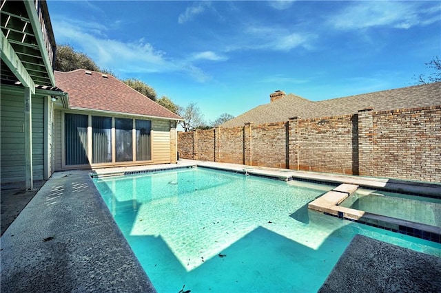 view of pool featuring a fenced backyard and a pool with connected hot tub