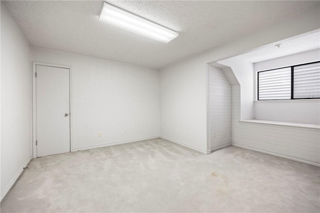 bonus room with light carpet and a textured ceiling