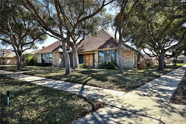 view of front of home with stone siding and a front yard