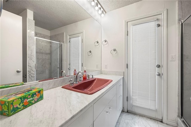 bathroom with marble finish floor, a textured ceiling, vanity, and a shower stall