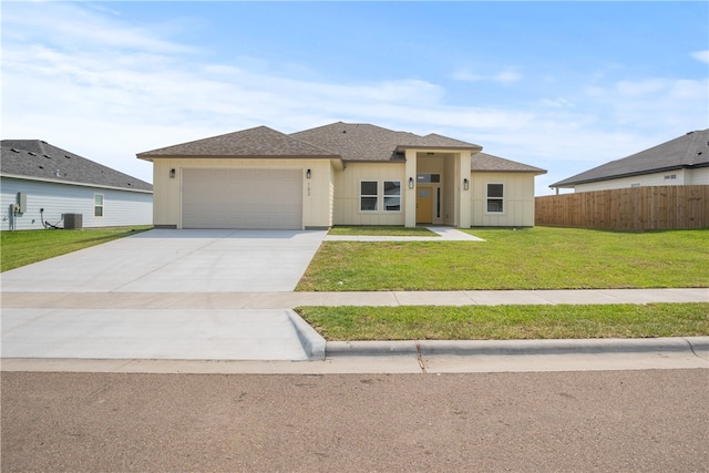 view of front of property featuring central AC unit, a garage, and a front yard