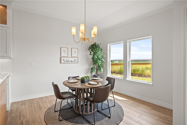 dining room featuring an inviting chandelier, ornamental molding, and light hardwood / wood-style flooring